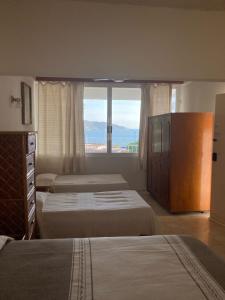 阿卡普尔科Villa Covadonga的酒店客房设有两张床和大窗户。