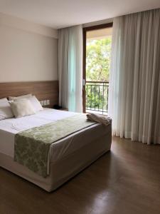 佩德拉阿祖尔Cond Vista Azul的一间卧室设有一张大床和一个窗户。