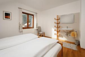 格伦德尔湖Haus Grundlsee的白色卧室设有床铺和水槽