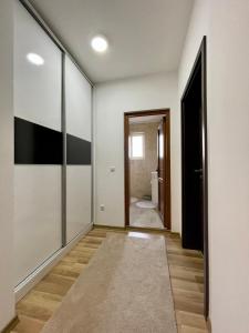 普里什蒂纳Luxury private House, near center的一条带白色墙壁的走廊和一扇通往浴室的门