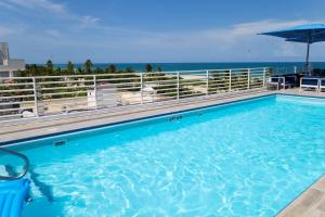 迈阿密海滩1-Bed Apt with rooftop pool Ocean Dr by the Beach的一个大型的游泳池,背景是大海