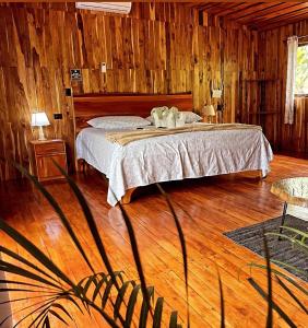 Rio CelesteCacahua Paradise Lodge, Río Celeste的一间卧室配有一张床,铺有木地板
