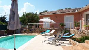 吉索纳恰Villa BRIMI的房屋旁的游泳池配有椅子和遮阳伞