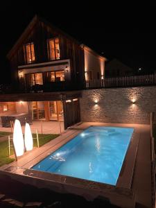 BettelChalets Petry Spa & Relax的夜间在房子前面的游泳池