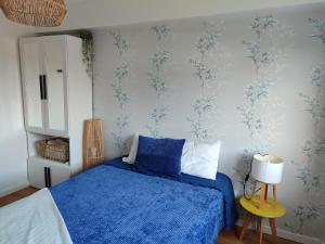 瓜尔达zélu apartamento centro da Guarda的一间卧室配有蓝色的床和蓝色壁纸