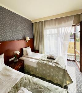 济夫努夫Hotel&Spa Stary Dziwnów basen swimming pool的酒店客房设有两张床和窗户。