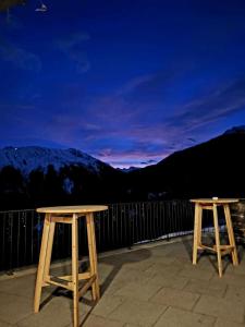 施伦斯Berggasthof Grabs的两个木桌,坐在山景阳台上