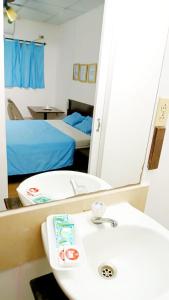马那瓜Orison Hostels Managua的一间带水槽和镜子的浴室以及一张床