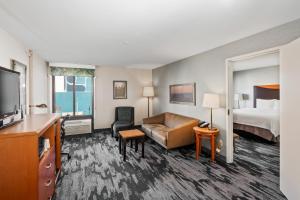 博伟公园Fairfield Inn & Suites Anaheim North Buena Park的酒店客房配有床、沙发和电视。