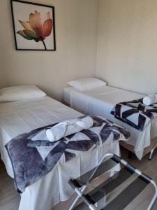 圣保罗Studio aeroporto Congonhas的一间设有两张床和椅子的房间