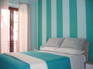 卡梅罗塔码头B&B Margherita的一间卧室配有一张蓝色和绿色条纹的床
