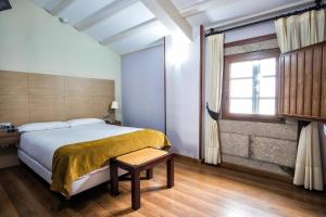 圣地亚哥－德孔波斯特拉Hotel Alda Bonaval的一间卧室设有一张大床和一个窗户。