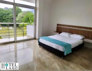 莫科阿Hotel El Lago的一间卧室设有一张床和一个大窗户