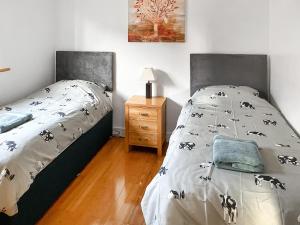 Old BuckenhamCedar Lodge的一间卧室配有一张床和一个带床罩的床头柜。