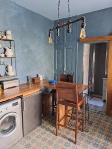 布尔日Chambre bleue avec accès plage的厨房配有桌子和洗衣机。