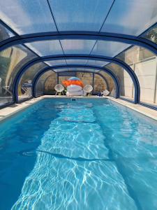 布尔日Chambre bleue avec accès plage的一个带蓝色游泳池的大型游泳池