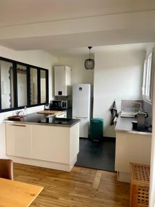雷恩Le 30 Rennais - T4 en plein centre ville的厨房配有白色橱柜和白色冰箱。