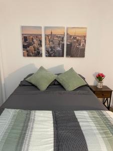 纽约Comfy Guest House by Columbus Circle的卧室配有一张墙上三幅照片的床