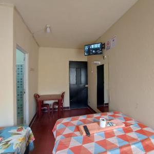 危地马拉Hotel Villas de San Juan, Guatemala的一间设有床铺和墙上电视的客房
