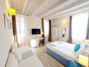 卡利亚里Hotel La Villa Del Mare的一间卧室配有两张床、一张桌子和一台电视。