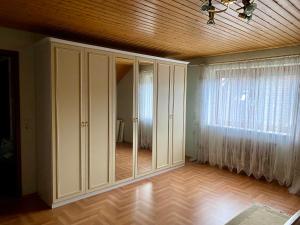 StutenseeSchöne Wohnung im Grünen的一间设有白色橱柜和大窗户的客房