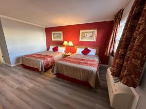 康沃尔HOTEL CLASSIC COMFORT的酒店客房,设有两张带红色墙壁的床