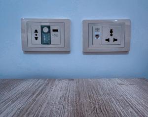 瓦迪穆萨Petra Caravan Guest House的蓝色墙壁上有两个灯开关,铺有木地板