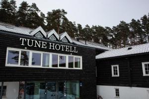 萨普斯堡Tune Hotell Sarpsborg的一座黑色的建筑,上面写着单词时间酒店