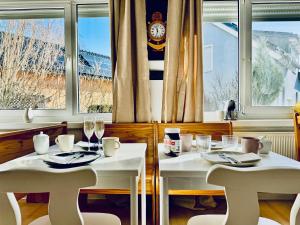 伯尔格伦德-雷特维施Pension Ostsee-Strand的餐厅设有两把白色的桌椅,设有窗户