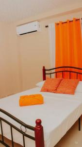 圣地亚哥San Juan Loft的一间卧室配有一张带橙色窗帘的床