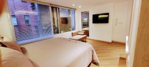 波哥大玛格丽塔公寓的一间卧室设有一张床和一个大窗户