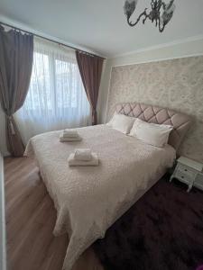 博托沙尼Apartament in Botosani的一间卧室配有一张大床和两条毛巾