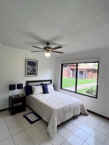 利比里亚Apartamento Guanacaste Liberia, Piscina, Cama King的一间卧室配有一张床和吊扇