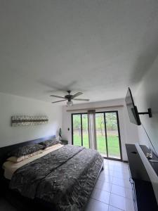 利比里亚Apartamento Guanacaste Liberia, Piscina, Cama King的一间卧室配有一张床和吊扇
