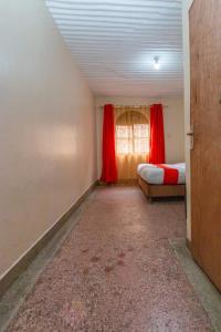 内罗毕City Space Hotel的客房设有两张床和一个带红色窗帘的窗户。