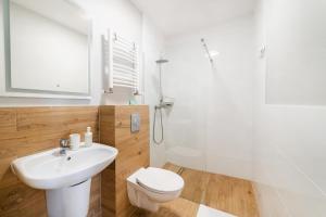 亚斯塔尔尼亚Apartamenty Białe Piaski的浴室配有卫生间、盥洗盆和淋浴。
