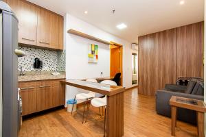 巴西利亚GS Properties - Nobile Monumental的厨房以及带桌子和沙发的客厅。
