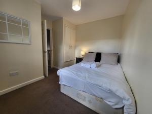 伦敦Great Apartment Next To Tooting Bec Tube Station!的一间卧室配有带白色床单和枕头的床。