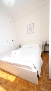 埃尔莫波利斯Cozy Apartment in Hermoupolis的白色客房的一张白色床,铺有木地板