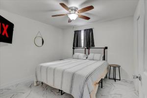 橙县Stylishly Remodeled 2-Bedroom home in Orangefield的一间卧室配有一张带吊扇的床