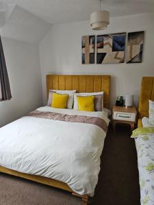 塔姆沃思The Gungate的一间卧室配有一张带黄色枕头的大床