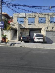圣萨尔瓦多Apto. mejor zona de San Salvador的两辆汽车停在大楼前的停车场