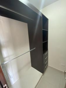 ArraijÃ¡nUrban Retreat的步入式衣柜,配有黑色冰箱