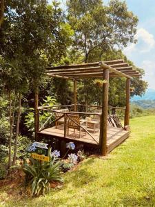 Refúgio do Sol Park Pousada - Cabana - Hospedagem的田野上带凉棚的木甲板