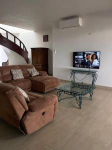 基诺湾Hermosa casa a la orilla del mar的客厅配有沙发和墙上的电视