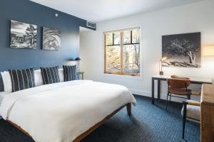 特拉基Gravity Haus Truckee-Tahoe的卧室配有一张白色大床和一张书桌