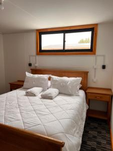纳塔列斯港Hostal B&B Coastal Natales的卧室配有一张大白色床和窗户