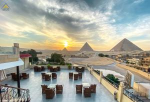 开罗Egypt Pyramids Inn的从酒店享有金字塔景色的阳台欣赏日落美景