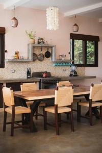 El PlantelPerfect family home in Playa Maderas的厨房配有大型木桌和椅子