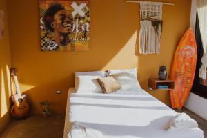 El PlantelPerfect family home in Playa Maderas的卧室配有一张床,墙上设有冲浪板